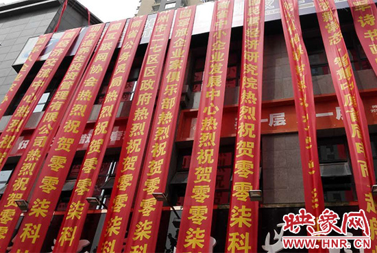 路邊一棟樓上懸掛著二三十條紅色條幅，全部是祝賀一家公司開業(yè)的。