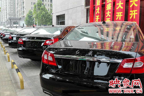 路邊一棟樓上懸掛著二三十條紅色條幅，全部是祝賀一家公司開業(yè)的。
