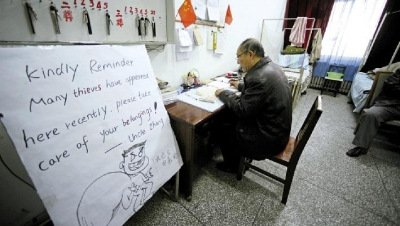 張大爺在門(mén)衛(wèi)室里工作，旁邊是紅爆網(wǎng)絡(luò)的溫馨提示牌記者