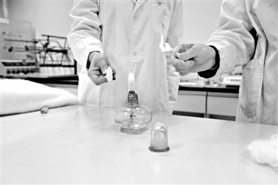 實驗人員操作的燃燒檢測法中，真蠶絲離開火焰就熄滅(左)。