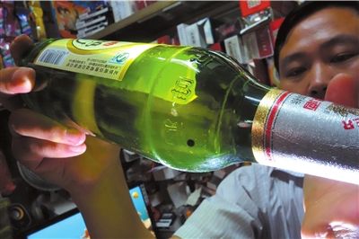 這瓶未開(kāi)封的燕京啤酒內(nèi)有一顆黑色懸浮物。京華時(shí)報(bào)記者 徐曉帆 攝