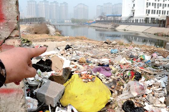 金水河長江路橋下河水發(fā)臭，水邊堆放眾多垃圾