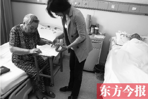 昨日，鄭大五附院二號(hào)樓住院部，馬老太寫下委托書，并簽字摁指印委托女兒代理為昏迷老伴解鎖取錢