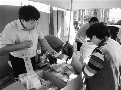 昨日，河南企業(yè)家劉春喜在京“練攤”，為顧客挑選綠豆。新京報記者 張玉學(xué) 攝