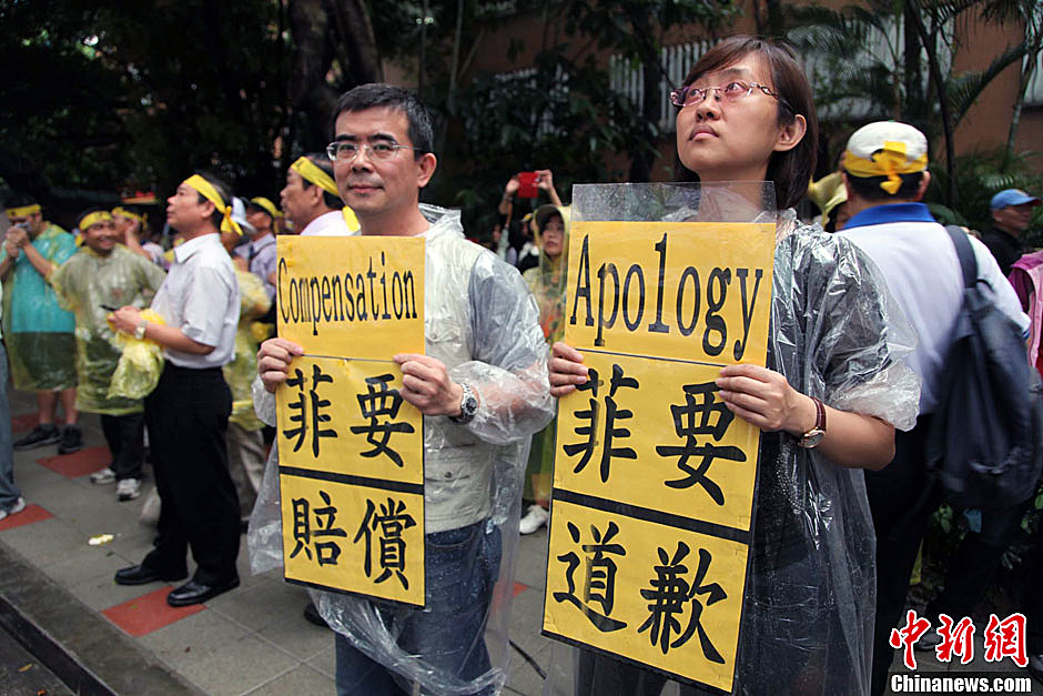 　圖為當(dāng)天下午，當(dāng)臺灣數(shù)百漁民在馬尼拉經(jīng)濟(jì)文化辦事處前抗議時，有兩名年輕人手持標(biāo)語，在路邊聲援。中新