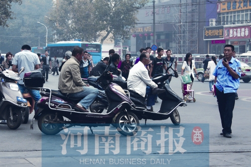 　火車站廣場北側(cè)，幾輛摩的正在等客