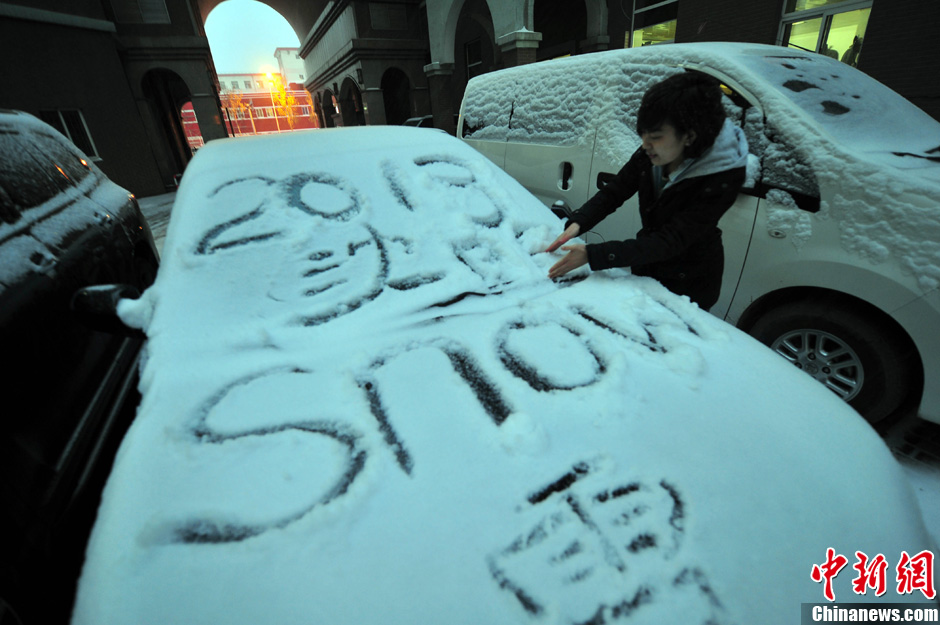 11月18日，行人在車輛的積雪上涂鴉。