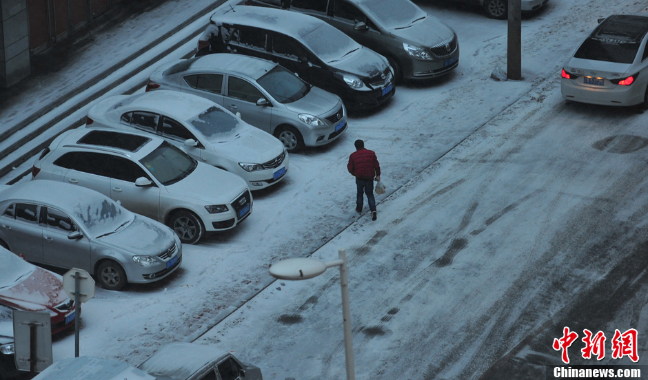 11月18日，行人在沈陽街頭的積雪中穿行。