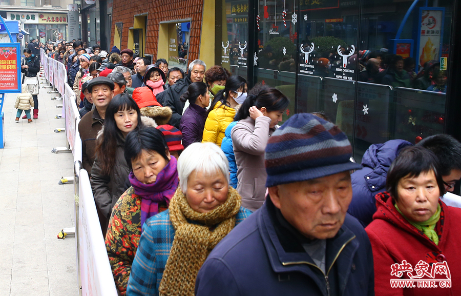 領(lǐng)粥的市民排起了長隊(duì)，足有上千人。