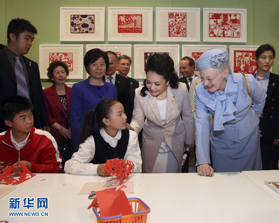 這是彭麗媛和瑪格麗特二世與根據(jù)安徒生童話中人物和情節(jié)制作剪紙的孩子交談。