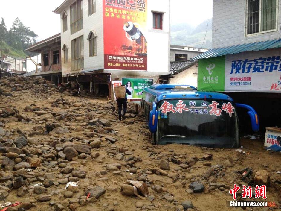 圖為山洪泥石流導沖進鄉(xiāng)鎮(zhèn)街道，導致客車被埋。