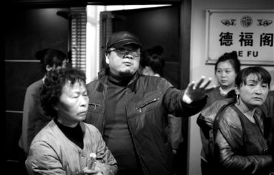 昨日，在河北香河天下第一城，相關(guān)負(fù)責(zé)人（左二）走出會議室與參加演出的老人們溝通。