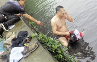 網(wǎng)友貼出民警張光聰一出河水就睜不開(kāi)眼，用手抹去臉上臟水的照片。