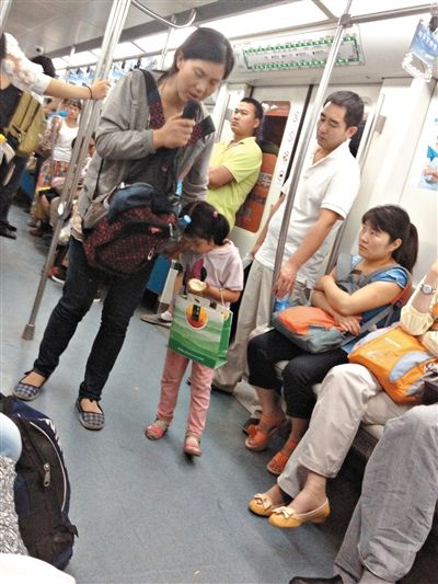 6月27日，舒馨帶一女孩在地鐵十號(hào)線行乞。她因被疑帶多個(gè)不同小孩乞討被警方搜尋。新京報(bào)記者 申志民 攝