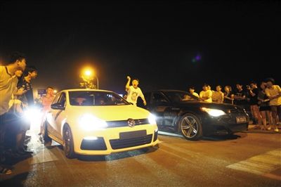 8月24日晚，東壩中街飆車(chē)現(xiàn)場(chǎng)，兩輛車(chē)并排等待出發(fā)指令，旁邊許多愛(ài)好者前來(lái)觀(guān)看比賽。新京報(bào)記者