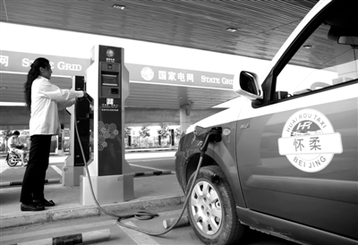 9月11日，懷柔區(qū)，電動(dòng)出租車司機(jī)正在為車輛充電。
