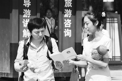 9月13日，西安臨潼華清池景區(qū)服務人員向游客介紹《旅游法》。