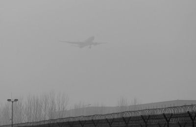 在首都機(jī)場(chǎng)，飛機(jī)在霧霾中降落。