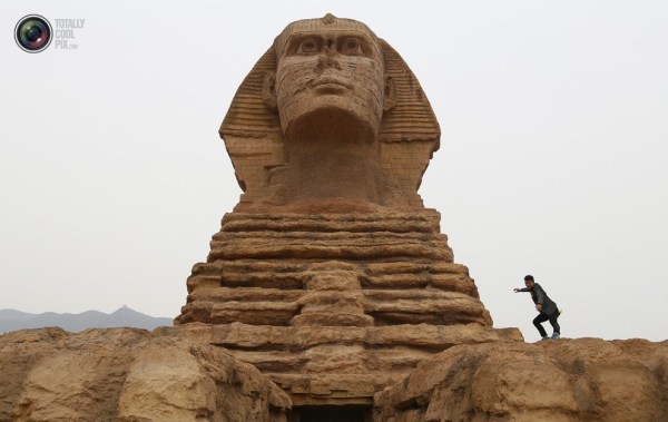 石家莊郊外，一名男子與山寨版獅身人面像合影留念。