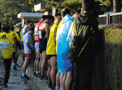 2013年10月20日，北京馬拉松比賽，由于廁位有限，一些選手在綠化帶“就地解決”。圖/IC