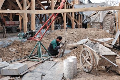東城區(qū)北鑼鼓巷與小經廠胡同之間一處四合院內，工人進入已經挖好的地下室內施工。