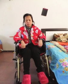陳慶霞坐在輪椅上。她現(xiàn)在下身癱瘓，疾病纏身，生活不能自理。