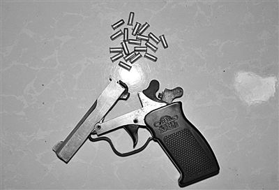 警方從搶劫嫌疑人處起獲的贓款和發(fā)令槍、子彈。警方供圖