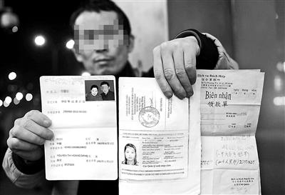 賀先生向記者出示他與越南妻子的結(jié)婚證、新娘護照和部分相關(guān)交費單據(jù) 攝影/本報記者　袁藝