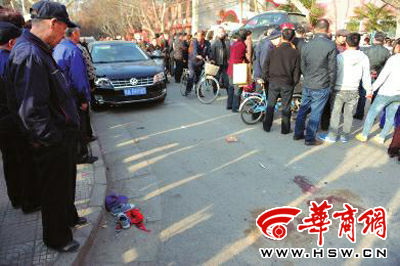車禍現(xiàn)場的血跡被人用土覆蓋，旁邊則放著紅領(lǐng)巾、一雙童鞋和一頂帽子 本報記者 趙彬 攝