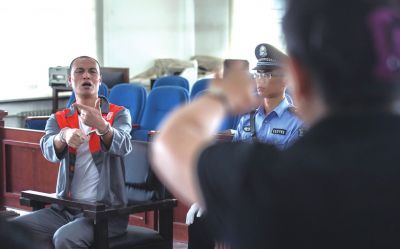 張志國在法庭上用手語回答提問。記者 蒲東峰攝