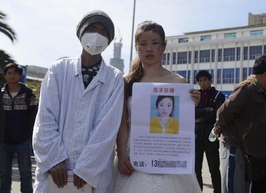 昆明火車站廣場上，24歲的黃習(xí)菊身穿潔白的婚紗，帶著身患白血病的弟弟征婚。