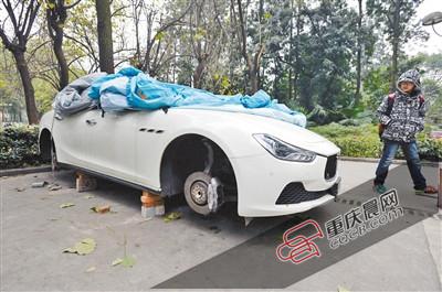 昨日，停放在重慶大學(xué)B區(qū)的一輛瑪莎拉蒂豪車被架在幾塊磚頭上，車輪不翼而飛。 重慶晨報(bào)記者 胡杰 攝