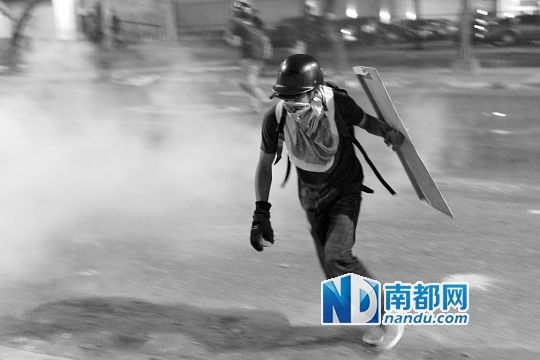反政府示威者在與警察的沖突中躲避催淚彈。