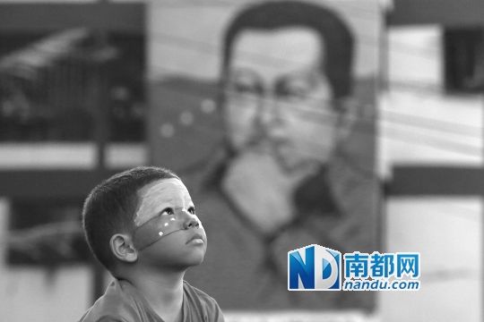 3月5日，一名委內(nèi)瑞拉兒童仰望天空，他身后是查韋斯的陵墓。