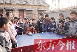 坐著輪椅的小宗成和同學(xué)們一塊打乒乓球，這是他感到最快樂(lè)的事