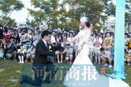 在學(xué)校操場的草坪上，兩名畢業(yè)生舉行婚禮，有同學(xué)感動地抹起眼淚