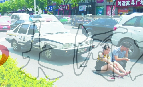 事故發(fā)生后，警車司機(jī)（右）下車查看傷者并撥打120，倆“領(lǐng)導(dǎo)”穩(wěn)坐車內(nèi)引發(fā)圍觀者不滿。
