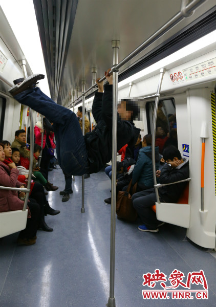地鐵試乘日，一男子在車廂內(nèi)攀爬扶手自娛自樂
