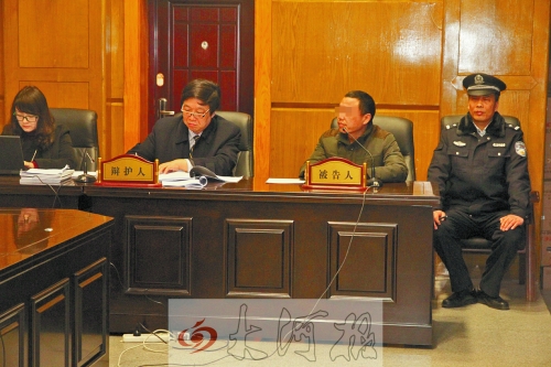 庭審現(xiàn)場，被告人坐在律師身旁為自己辯護。