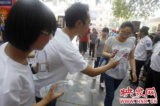 志愿者為剛剛考試完的考生送上1瓶冰凍的冰露·純悅，消暑解渴為考生加油