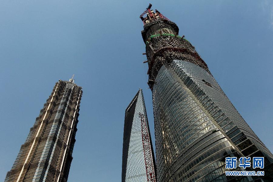 4月11日，正在建設(shè)中的“上海中心”（右）的高度已超過金茂大廈（左）和上海環(huán)球金融中心（中）。