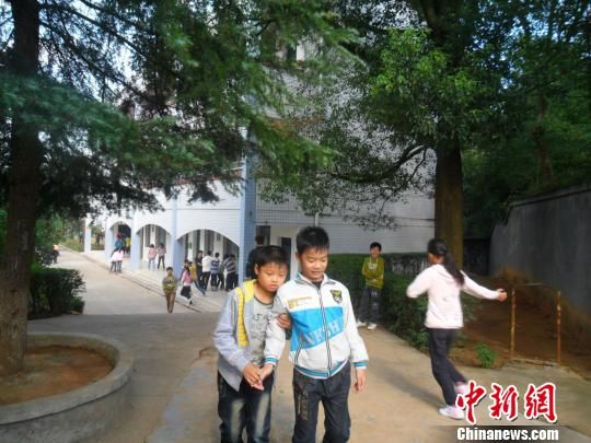 4年來，13歲的余興泉（左一）每天都攙扶著腿腳不便的同學(xué)左臣進(jìn)出教室、食堂和廁所。 李俊杰 攝
