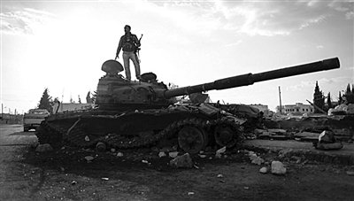 9月8日，敘利亞Zabadani，一名敘利亞反對派武裝人員站在廢棄的政府軍坦克上。