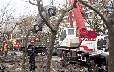 輸油管道爆炸后，搶修人員將被炸毀的車輛運出現(xiàn)場。