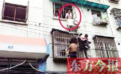 施救現(xiàn)場(chǎng)，劉鵬（圈內(nèi)）先用繩子捆住老太確保安全 勞動(dòng)報(bào)記者 郭娜 供圖