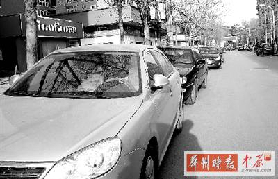 友愛(ài)路，路邊停了一排車，本來(lái)不寬的路就變得更窄了。