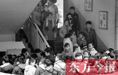 　某小學(xué)的學(xué)生走下樓梯放學(xué)。