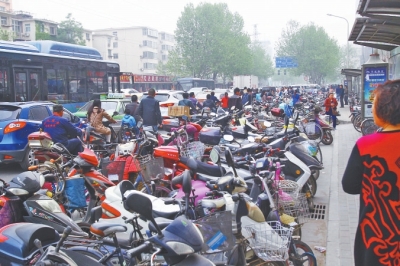省人民醫(yī)院北門，路邊的公交站牌處停滿非機(jī)動車，上、下客只能在快車道上。