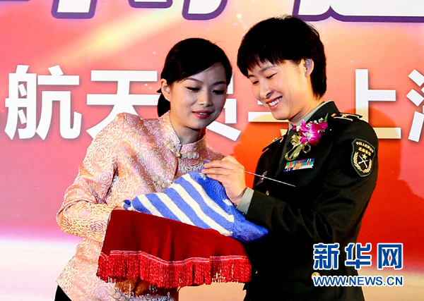 11月1日，航天員劉洋（右）在為“愛心”毛衣編織最后的收尾針。