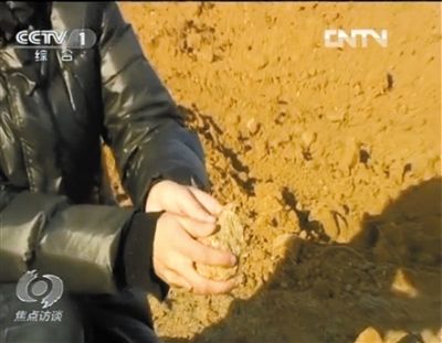 麻剛沙系麻剛石粉碎而成。記者找到一塊麻剛石，一捏就碎成粉末，硬度非常差。央視截圖